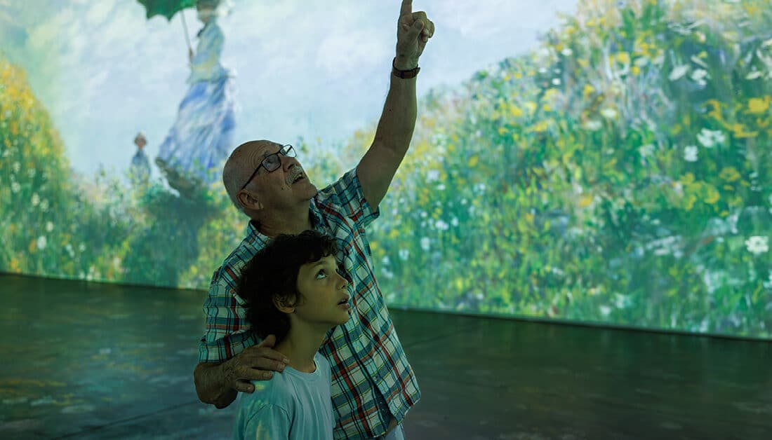A man and child looking at Claude Monet's artwork.
